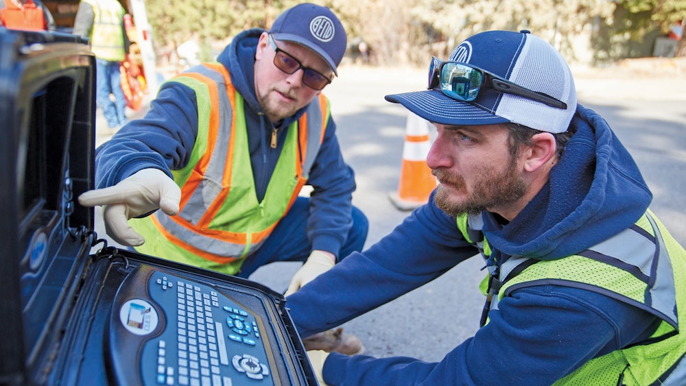 Two people looking at SL-RAT technology on the street